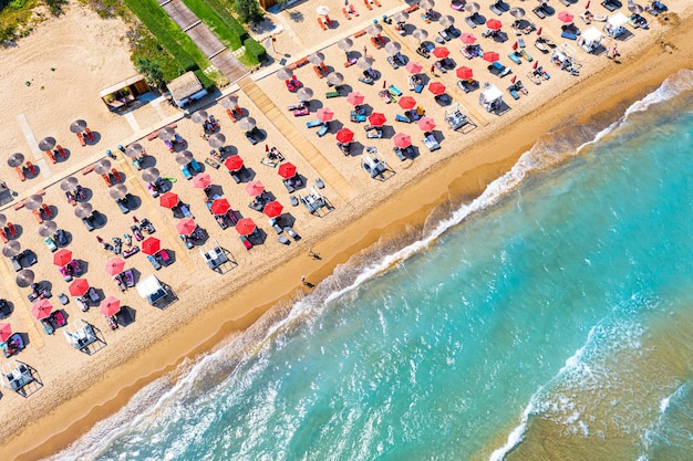 Bovenaanzicht luchtfoto drone foto van banaan strand met prachtige turquoise water zee golven en rode parasols vakantie reizen achtergrond Ionische zee Zakynthos eiland Griekenland