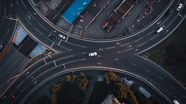 Bovenaanzicht luchtfoto drone shot van asfaltweg met auto's in de avondstad