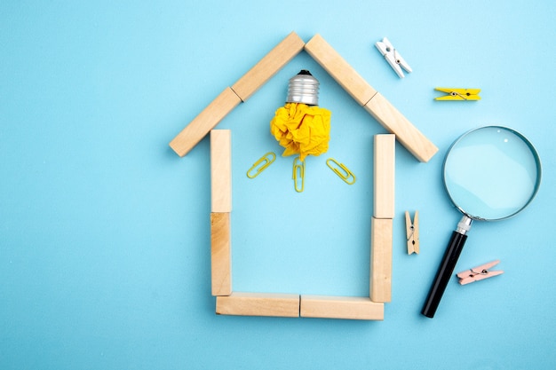 bovenaanzicht lupa idea gloeilamp in huis vormige houtblokken kleine wasknijpers op blauwe achtergrond vrije ruimte
