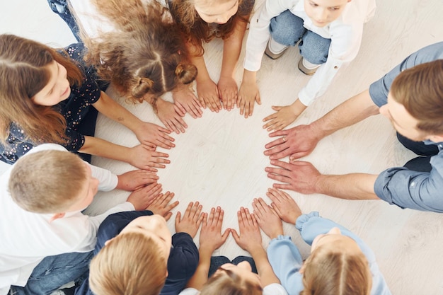 Bovenaanzicht Man met zijn kinderen studenten in hand in hand voor succes Conceptie van onderwijs