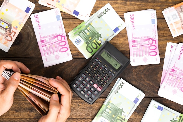 Foto bovenaanzicht man tellen van geld met calculator