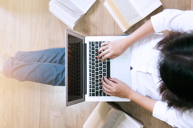 Bovenaanzicht meisje zittend op de vloer en werken met laptop of notitieboek student studeren. Kopieer ruimte voor tekst.