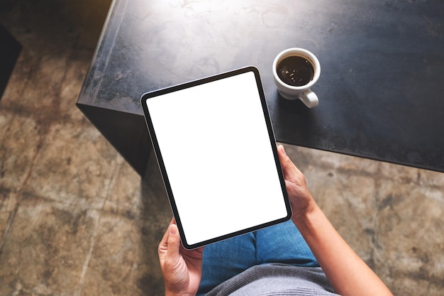 Bovenaanzicht mockup afbeelding van een vrouw met digitale tablet met leeg wit desktopscherm in café