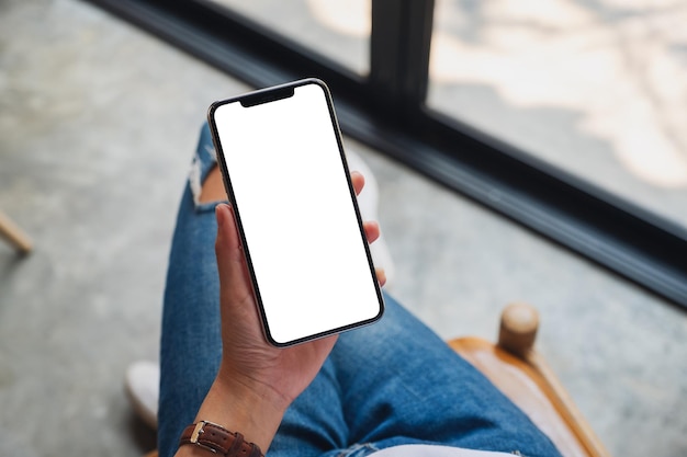 Foto bovenaanzicht mockup afbeelding van een vrouw met een mobiele telefoon met een leeg wit scherm