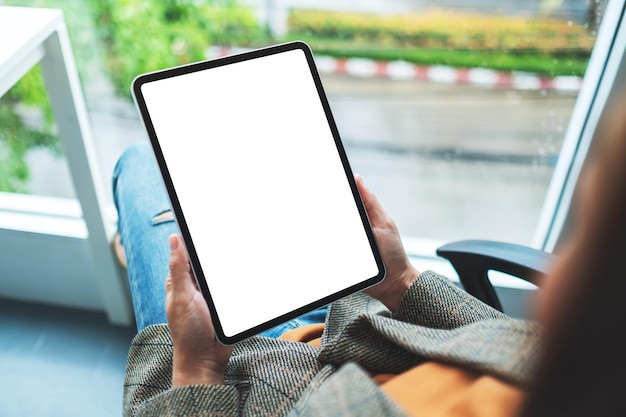 Bovenaanzicht mockup-afbeelding van een zakenvrouw met digitale tablet met een leeg wit bureaubladscherm
