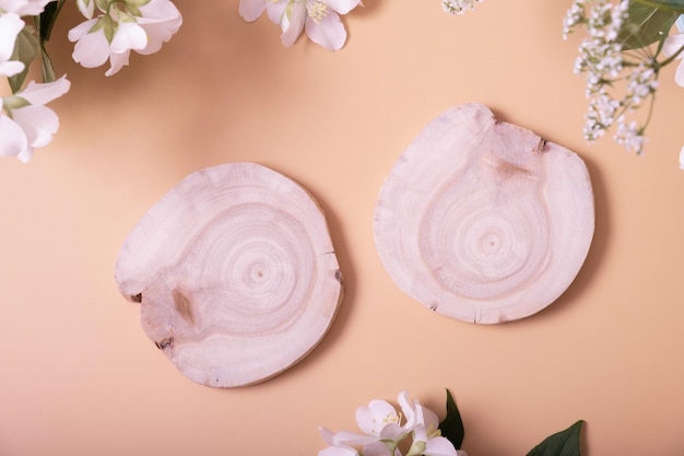 Bovenaanzicht natuurlijke minimale schoonheid houten sokkel Lege cosmetica-podia op beige achtergrond met bloemen voor product of jewerly