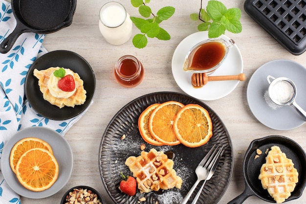 Bovenaanzicht Ontbijttafel met Croissantwafel of Croissant, Aardbei, Gesneden Sinaasappel, Honing en Ahornsiroop