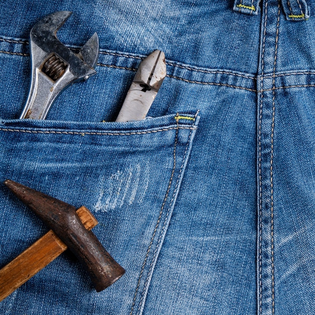 Bovenaanzicht ontwerpconcept van Labor Day met werkinstrumenten op blue jeans achtergrond.
