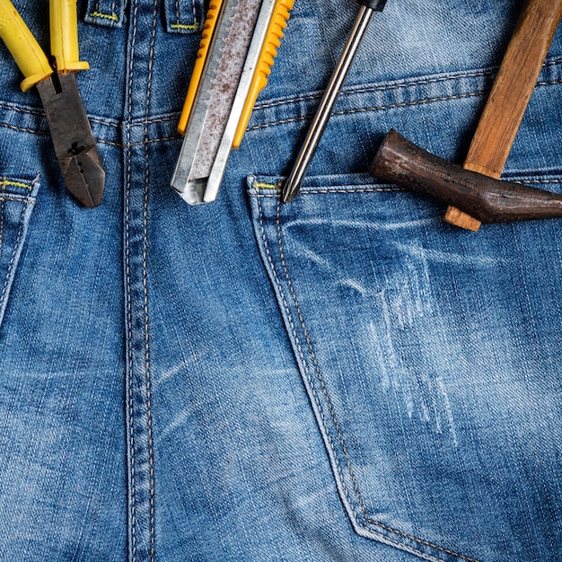 Bovenaanzicht ontwerpconcept van Labor Day met werkinstrumenten op blue jeans achtergrond.