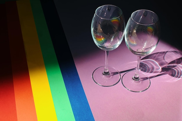 Bovenaanzicht op achtergronden van gekleurd papier die zijn neergelegd in de LGBT Pride Flag met twee glazen LGBT-vlagkleuren Vieringsconcept