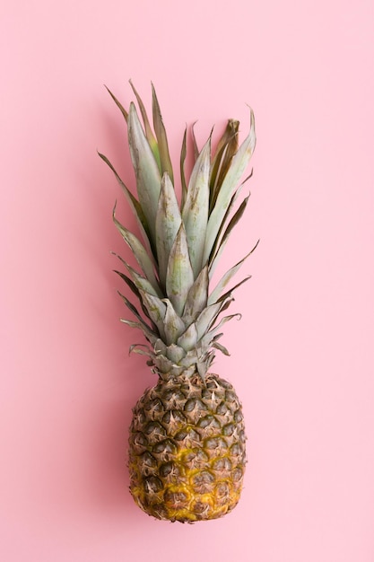 Bovenaanzicht op ananas op lichtroze achtergrond.