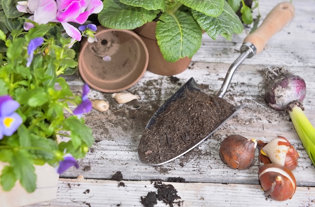 Bovenaanzicht op een schop vol met aarde en bloempotten op een tafel