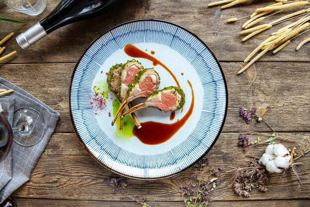 Bovenaanzicht op gastronomisch gekookte lamskoteletten met saus
