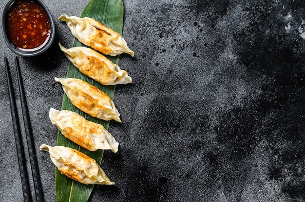 Bovenaanzicht op gebakken dumplings met dipsaus