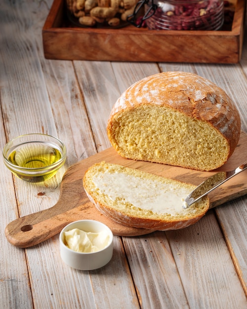 Bovenaanzicht op gesneden brood van olijfoliebrood met boter op de houten tafel