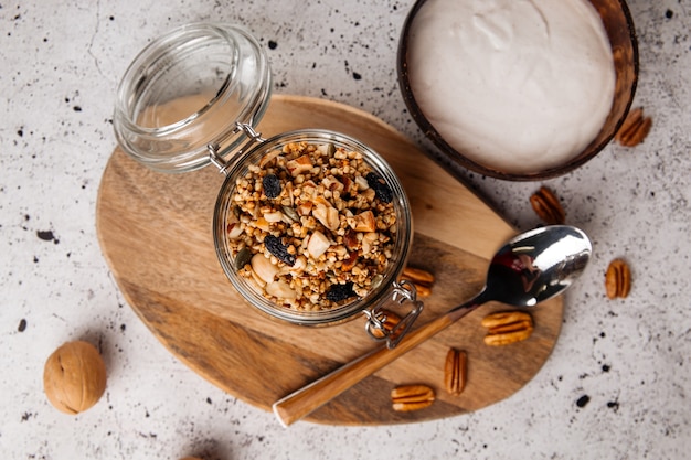 Bovenaanzicht op gezond ontbijt yoghurt in houten kom met muesli