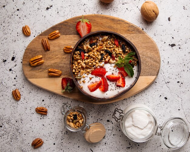 Bovenaanzicht op granola-yoghurt met aardbeien en chiazaad