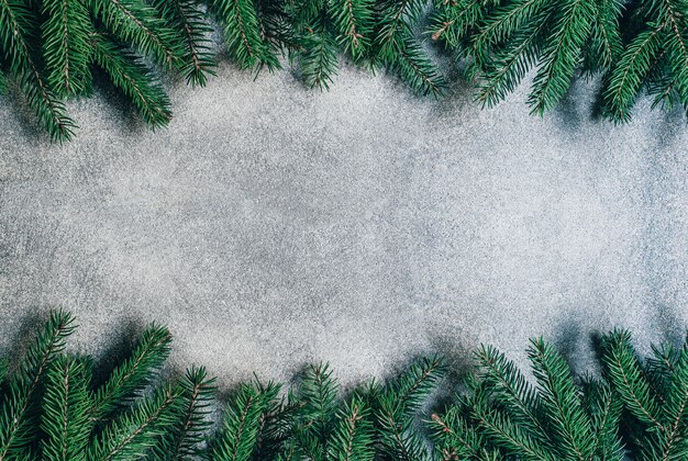 bovenaanzicht op grijze achtergrond met takken van een kerstboom