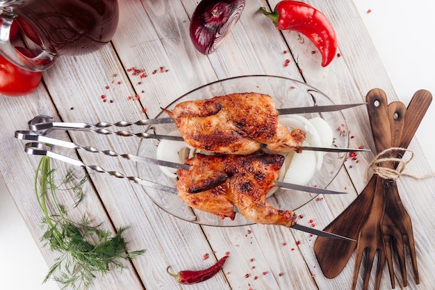 Bovenaanzicht op Kaukasische gegrilde kipspiesjes op de lichte houten tafel