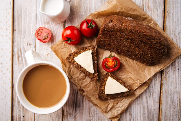 Bovenaanzicht op meelloos dieet graanbrood met kaas en koffie op de houten tafel