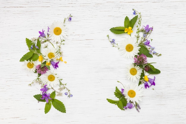 Bovenaanzicht op prachtige wilde bloemen op witte houten achtergrond