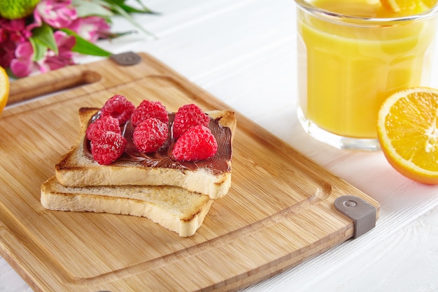 Bovenaanzicht op toast met pindakaas, frambozen en bananen