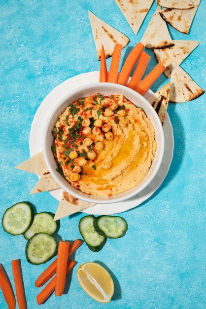 Bovenaanzicht over kleurrijke hummus met ingrediënten