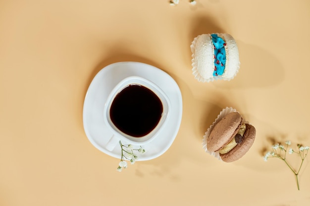 Bovenaanzicht plat lag cake macaron franse koekjes bitterkoekjes en kopje koffie