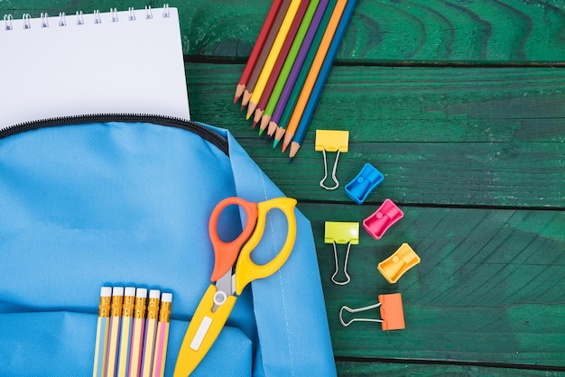 Bovenaanzicht plat leggen van blauwe schooltas rugzak en accessoires tools voor kinderen onderwijs