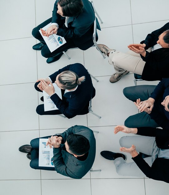 Bovenaanzicht. projectmanager die vragen stelt tijdens een bijeenkomst met de werkgroep. bedrijfsconcept.