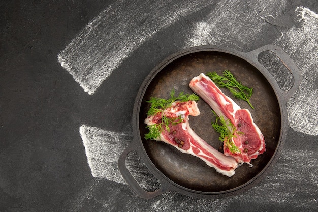 Bovenaanzicht rauw vlees plakjes met greens in pan op donkere achtergrond vlees kip salade groente koe foto dier