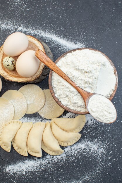 bovenaanzicht rauwe aardappel hotcakes met eieren en bloem op donkere achtergrond maaltijd taart koken biscuit taart bak deeg