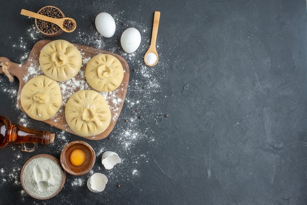 bovenaanzicht rauwe dumplings over snijplank met bloem