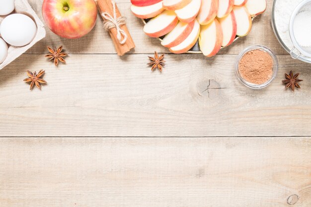 Bovenaanzicht rauwe ingrediënten voor het koken van appeltaart op houten achtergrond met kopie ruimte