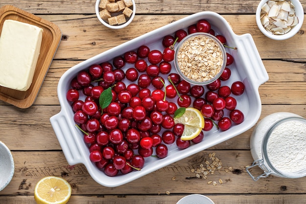 Bovenaanzicht rauwe ingrediënten voor het koken van kersentaart op houten tafel