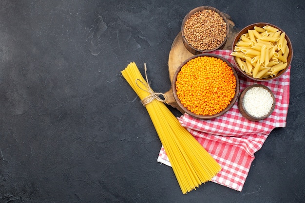 bovenaanzicht rauwe italiaanse pasta met linzen en boekweit op donkere achtergrond eten diner maaltijd koken keuken duisternis pasta deeg kleur