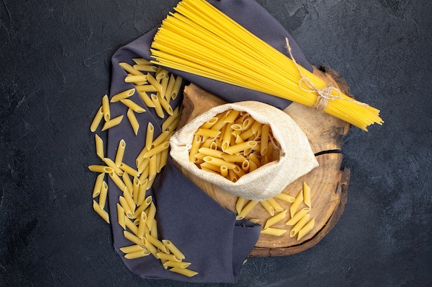 Bovenaanzicht rauwe pasta lang en weinig op donkere achtergrond eten pasta diner maaltijd koken kleur keuken duisternis