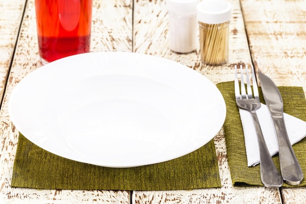 Bovenaanzicht rustieke witte tafel mockup lege ronde en witte plaat voor voedsel bestek aan de zijkant vintage achtergrond zelfgemaakte voedsel concept