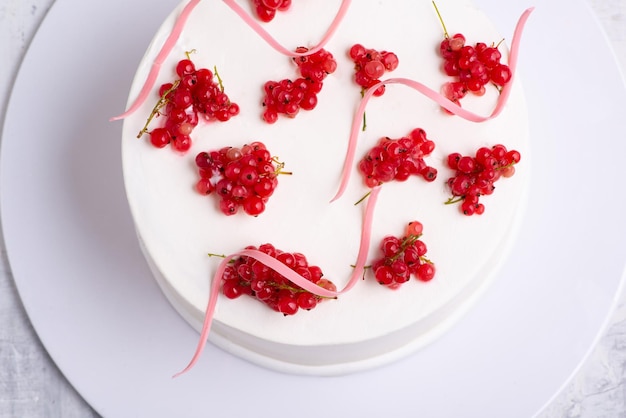 Bovenaanzicht shot van een witte cake ontworpen door rode bes op een witte plaat