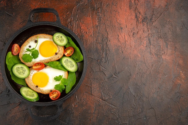 Bovenaanzicht smakelijke eiertoast met gesneden groenten in pan op donkere achtergrond maaltijd ei ontbijt eten bak kleurenfoto broodrooster