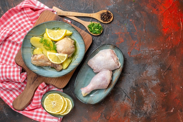 Bovenaanzicht smakelijke gekookte kip met gekookte aardappelen en citroen op donkere achtergrond keuken schotel olie kleur voedsel saus vlees calorie foto diner