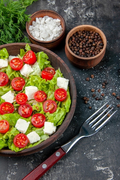 Bovenaanzicht smakelijke groentesalade met gesneden kaastomaten en kruiden op donkere achtergrond voedsel maaltijd dieet lunch kleur gezondheid