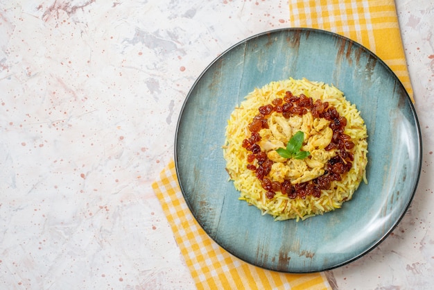 bovenaanzicht smakelijke plov op ronde plaat geel en wit geruit tafelkleed op tafel vrije ruimte