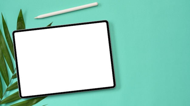 Bovenaanzicht Tablet-touchpad leeg schermmodel met styluspen en palmverlof op groene achtergrond
