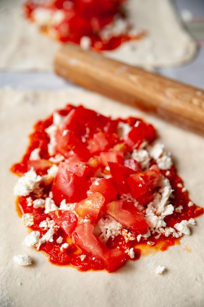 Bovenaanzicht tomatenvulling met kaas en rode chilipepersaus met kruiden voor burrito's