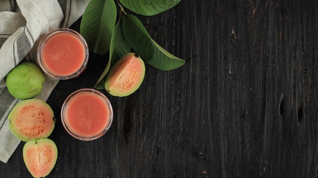 Bovenaanzicht twee glas Guava Smoothie Juice met kopie ruimte op zwarte houten tafel