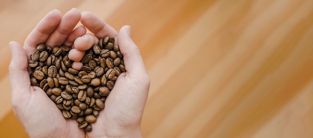 Foto bovenaanzicht van barista koffiebonen houden in hartvormige handen met kopie ruimte