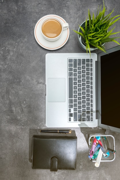 Bovenaanzicht van Bureau met laptop, koffie, potplanten, notebook en zakelijke accessoires