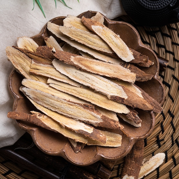 Bovenaanzicht van Chinese traditionele kruidengeneeskunde Astragalus wortel op houten tafel achtergrond.