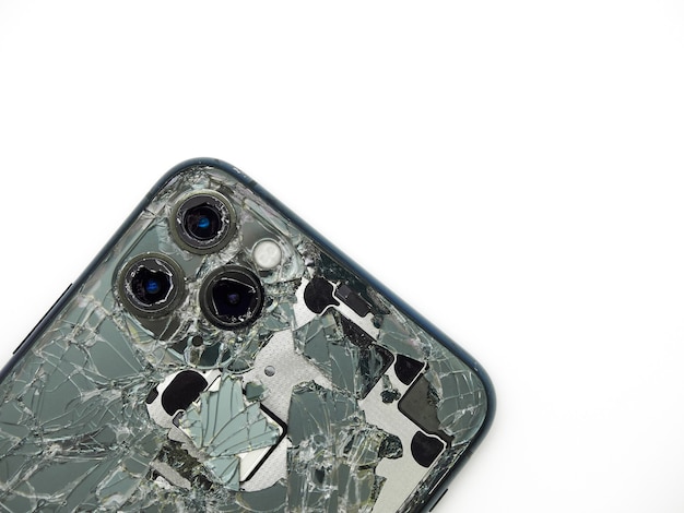 Bovenaanzicht van de achterkant van middernacht groene moderne smartphone met een gebroken glas en een beschadigde camera close-up geïsoleerd op een witte achtergrond